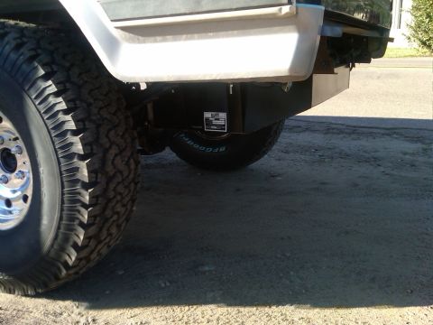 1986 Ford Bronco - Close-up of a truck's rear tire and fuel tank, with visible text on the tire and tank label.
