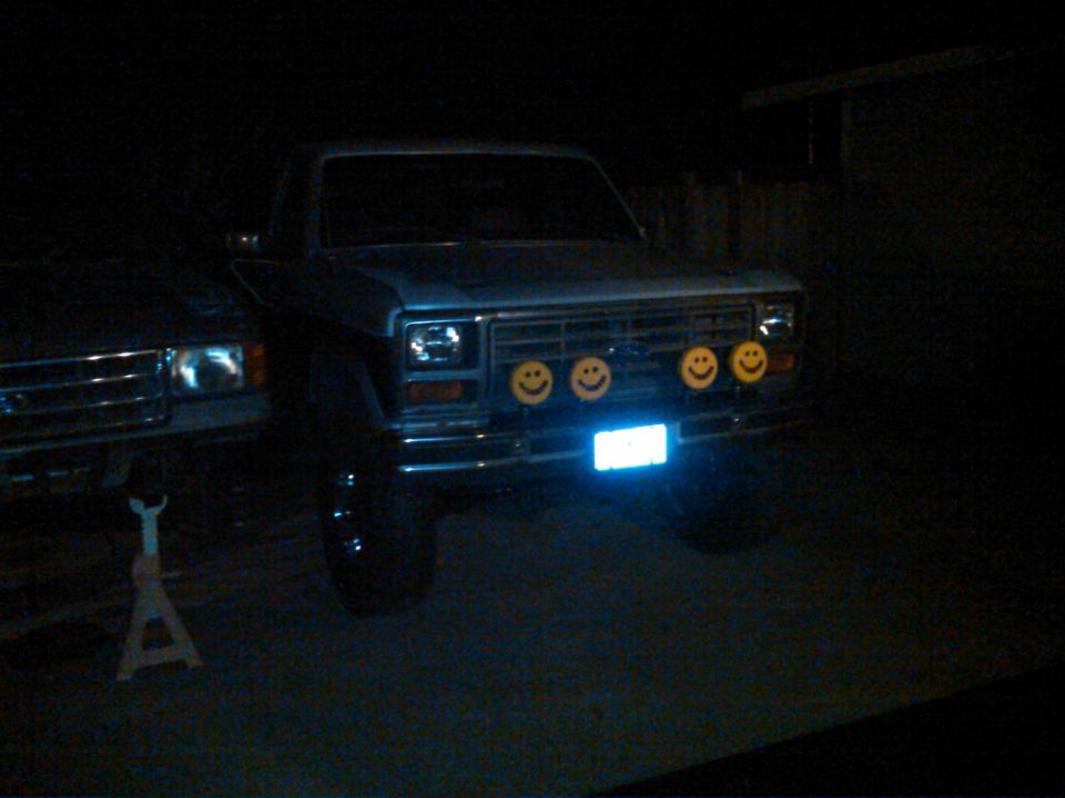 1986 Ford Bronco front view with four smiley face lights and a blue license plate