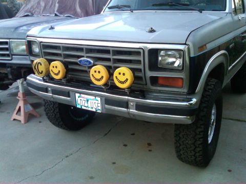 1986 Ford Bronco - This Ford truck features a chrome bumper and grille with four yellow KC lights mounted on the front.