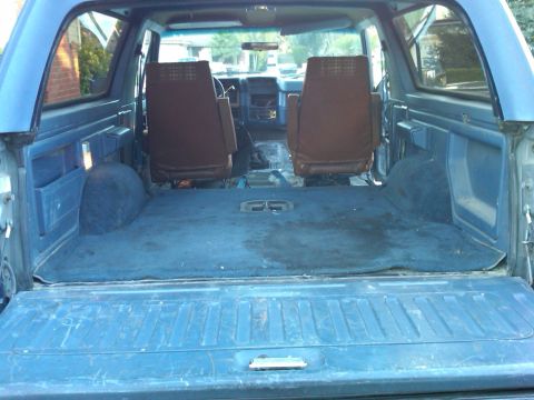 1986 Ford Bronco - Interior view of a blue SUV, showing the rear cargo area and front seats.