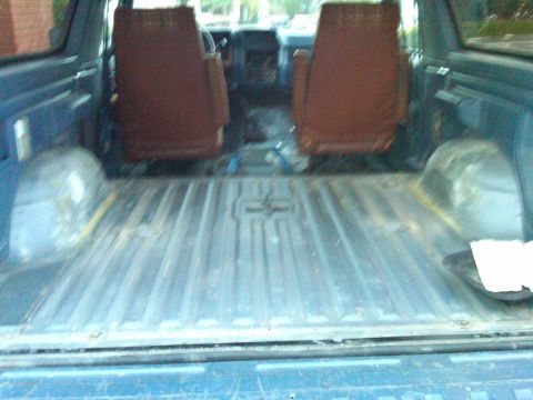 1986 Ford Bronco - Interior view of a blue SUV, focusing on the cargo space and front seats.