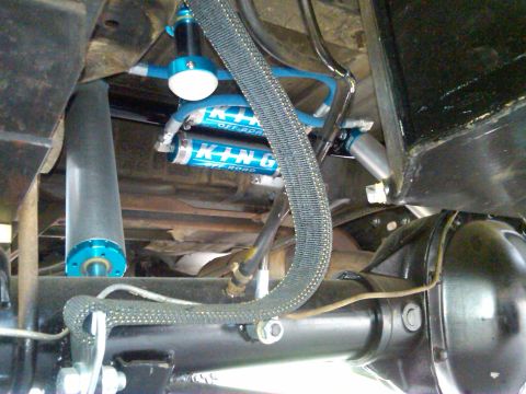 1986 Ford Bronco - Underside view of a vehicle's suspension system, highlighting custom shock absorbers.