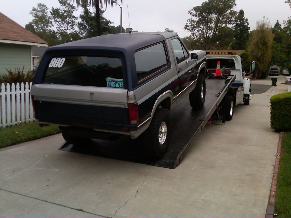 Ford Bronco on a tow truck flatbed, rear view. Number 890 on rear window