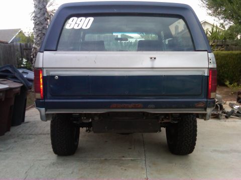 1986 Ford Bronco - This 1986 Ford Bronco features a distinctive two-tone paint job and a prominent '990' decal on its rear window.
