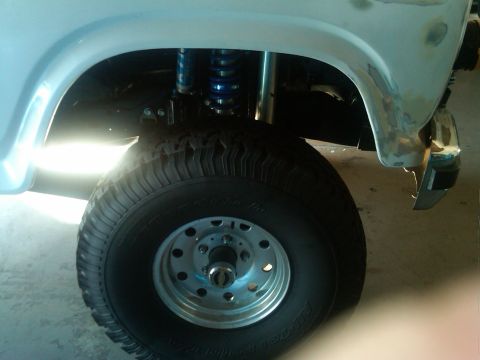 1986 Ford Bronco - Close-up of the front wheel and fender of a 1986 Ford Bronco, showing off its suspension and tire.