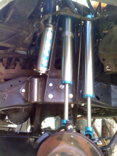1986 Ford Bronco - Custom suspension components, including multiple shock absorbers with blue accents, are visible in this close-up view.