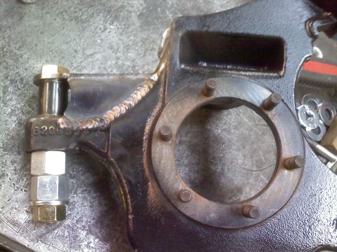 1986 Ford Bronco - Close-up of a heavy-duty automotive suspension part with detailed welds and mounting hardware.