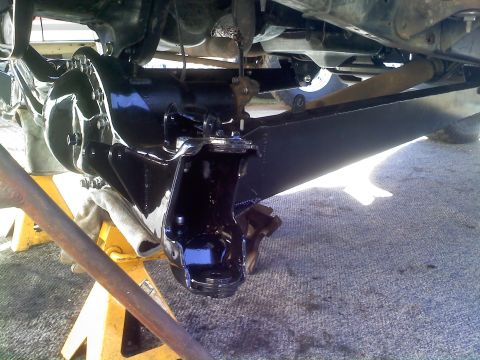 1986 Ford Bronco - Close-up view of a vehicle's rear axle assembly and suspension components, undergoing maintenance.