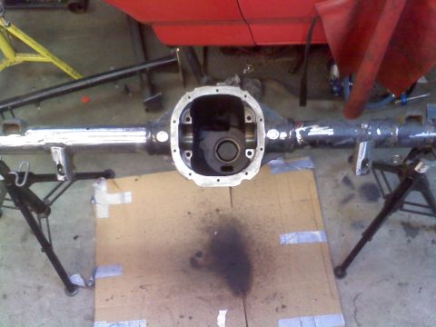 1986 Ford Bronco - Rear axle assembly removed from vehicle, resting on jack stands.