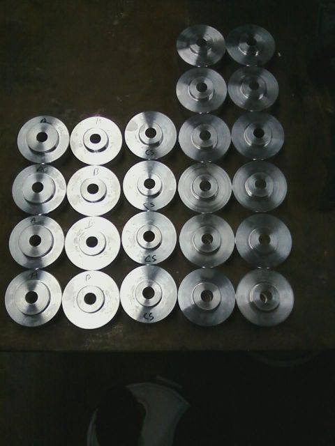 1986 Ford Bronco - Several metal discs, some labeled, are laid out on a dark surface.