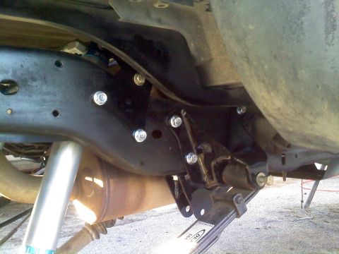 1986 Ford Bronco - Close-up view of the undercarriage, focusing on suspension components and exhaust system.