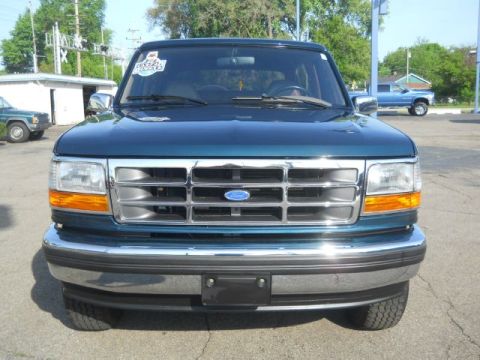 1994 Ford Bronco - Front view of a teal Ford Bronco with a chrome grille and bumper, parked outdoors.