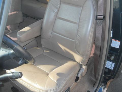 1994 Ford Bronco - The interior of the vehicle shows tan leather seats and a portion of the dashboard.