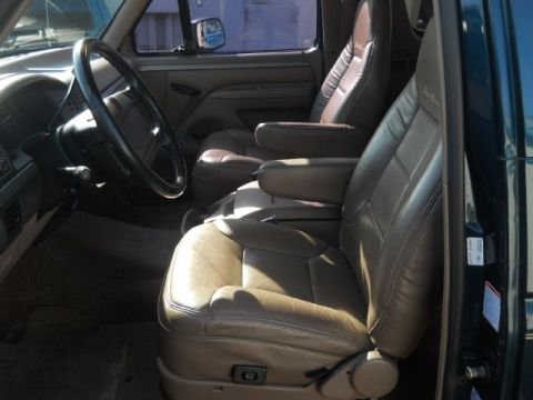 1994 Ford Bronco - The tan leather interior of a 1994 Ford Bronco shows the front seats and dashboard details.