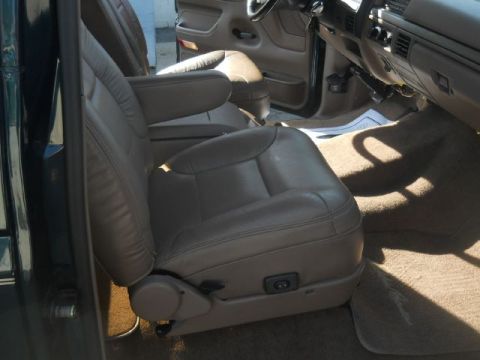 1994 Ford Bronco - The interior of a vehicle is shown, focusing on the tan leather front seats and the dashboard area.