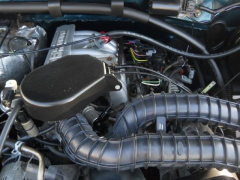 1994 Ford Bronco - Close-up view of the engine bay, showing intake hoses and the air filter housing.
