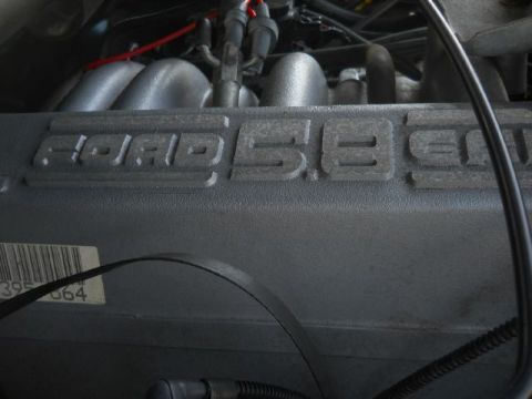 1994 Ford Bronco - The engine cover clearly shows 'FORD 5.8' embossed on it, indicating the engine displacement.