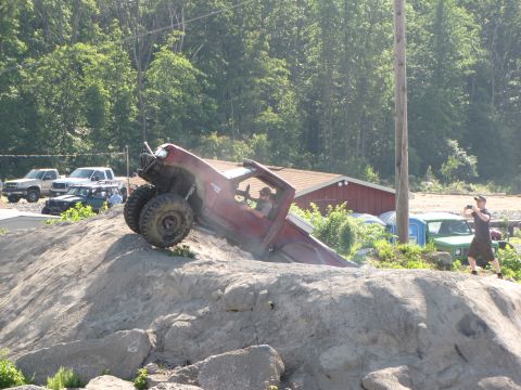 1979 Ford Bronco - A red off-road truck navigates a challenging rocky terrain during an event.