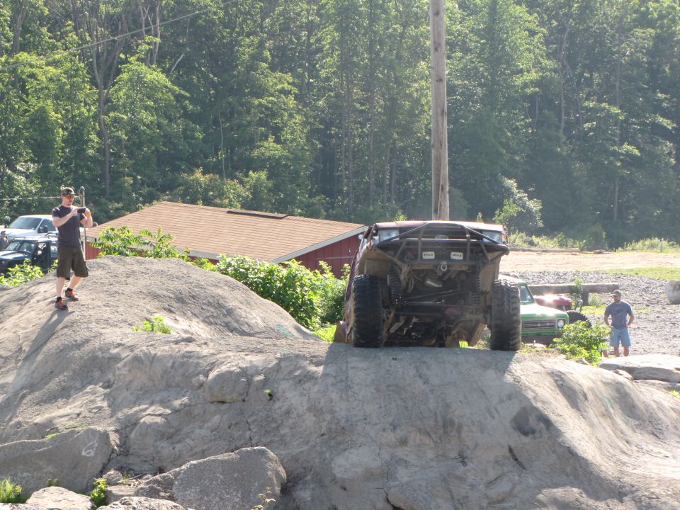 Rear view of off-road buggy climbing large rocks