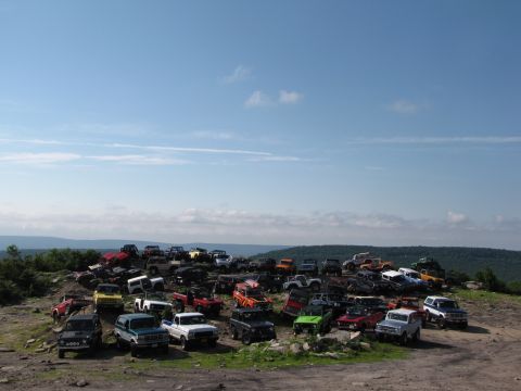 1979 Ford Bronco - A large gathering of off-road vehicles parked on a hill, likely at an event.
