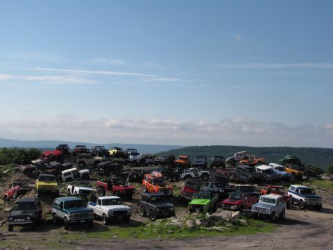 1979 Ford Bronco - A large group of various off-road vehicles are gathered on a hill.
