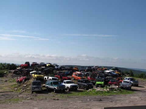 1979 Ford Bronco - A large gathering of off-road vehicles parked on a hill.
