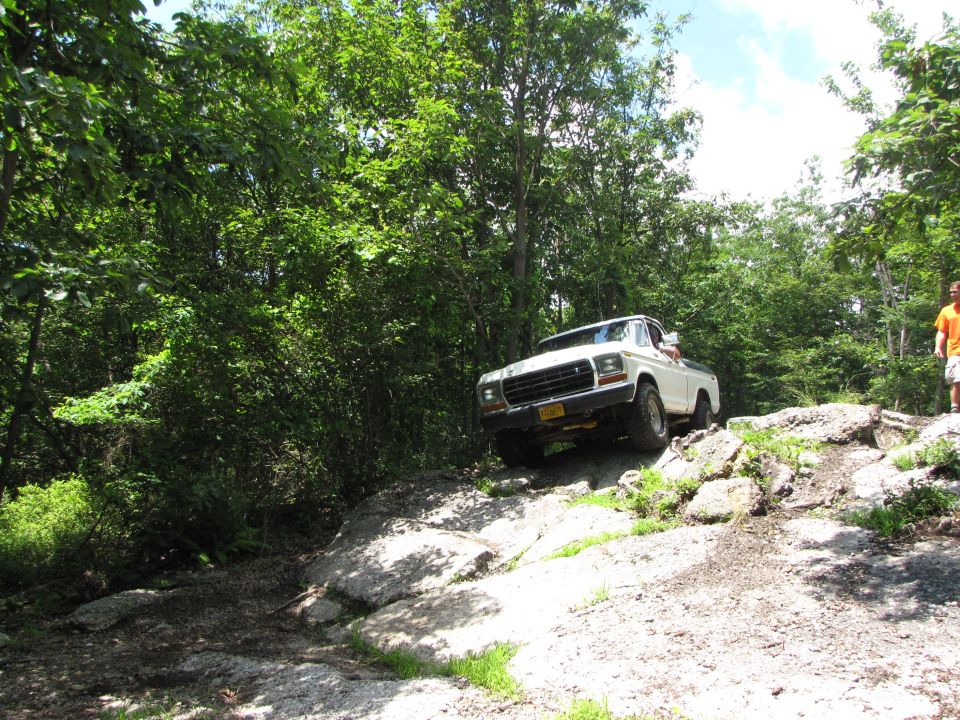 White pickup truck on rocky terrain, front grille visible