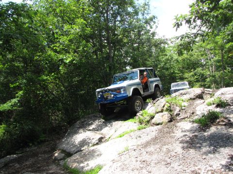1979 Ford Bronco - A white Ford Bronco navigates a rocky trail with another vehicle visible in the background.