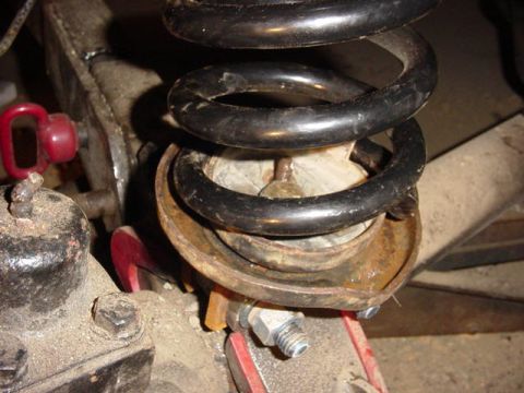 1992 Ford Bronco - Close-up view of a suspension coil spring and its mounting hardware, likely during installation or repair.