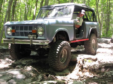 1979 Ford Bronco - This 1977 Ford Bronco is shown tackling a challenging off-road course in a wooded area.