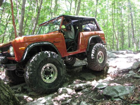 1979 Ford Bronco - This 1979 Ford Bronco is shown tackling a challenging off-road course with its modified suspension and tires.