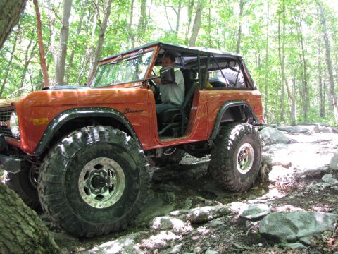 1979 Ford Bronco - This 1979 Ford Bronco is shown tackling a challenging off-road course with large tires and a lifted suspension.