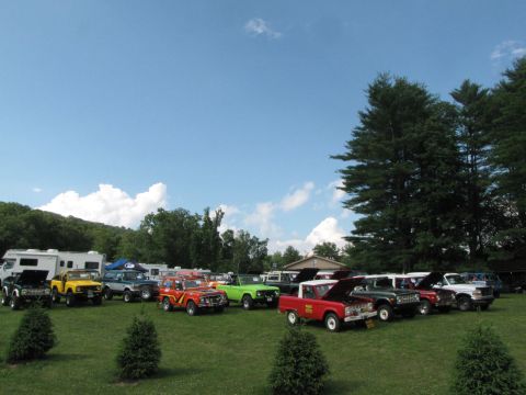1979 Ford Bronco - An outdoor gathering features a variety of vehicles, including multiple Ford Broncos, parked on a sunny day.