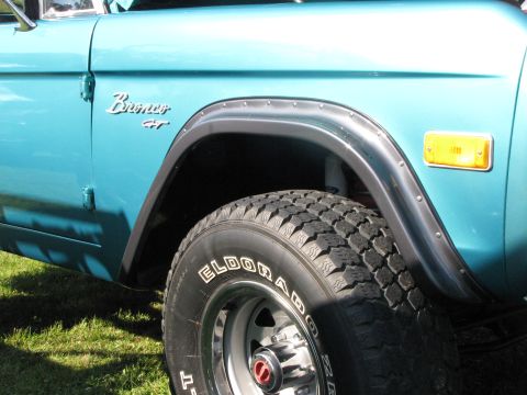 1979 Ford Bronco - The side profile of a teal Ford Bronco shows its distinctive fender flare and 'Bronco GT' badging.