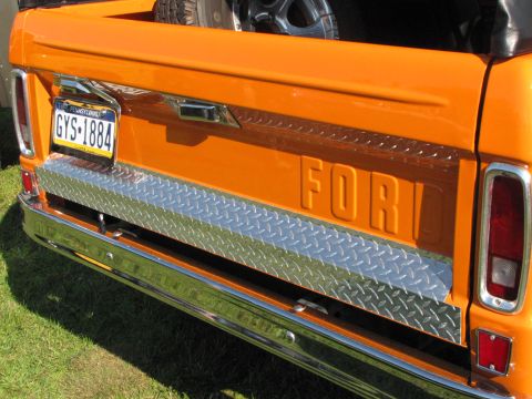 1979 Ford Bronco - Rear view of an orange Ford pickup truck, a diamond plate tailgate accent and a Pennsylvania license plate.