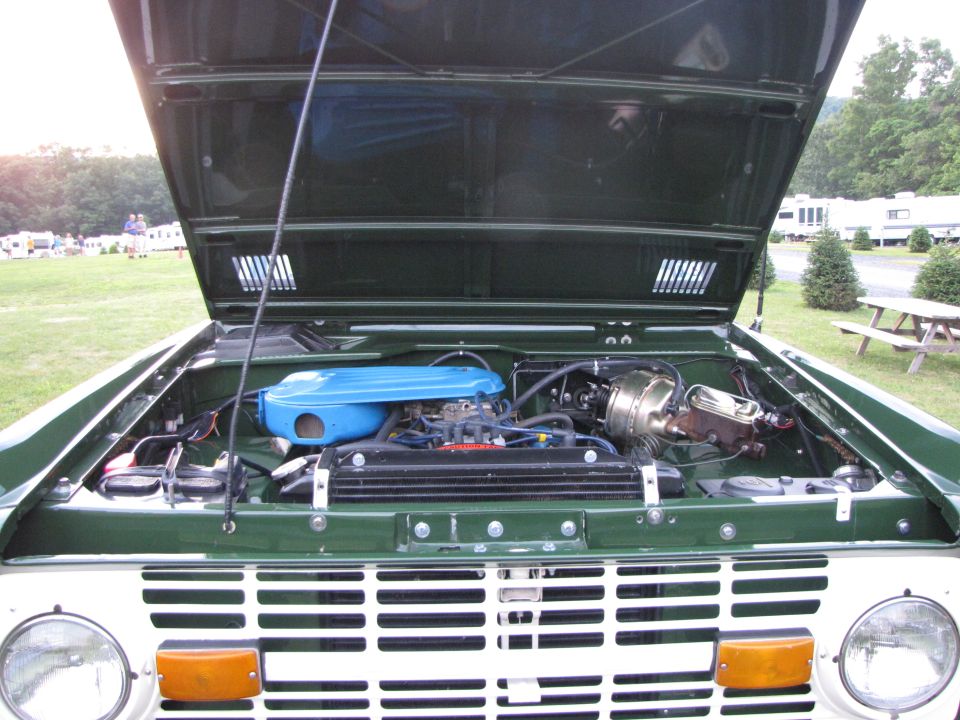 Green 1978 Ford Bronco engine bay with hood open, showing blue air cleaner and engine components