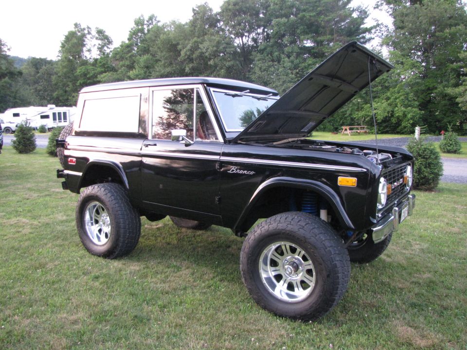 Black 1979 Ford Bronco with hood open, lifted suspension, and aftermarket wheels