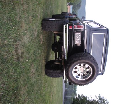 1979 Ford Bronco - This black SUV, likely a 1978 model, is viewed from the rear quarter with its large tires and chrome bumper visible.