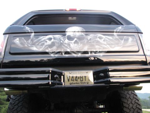 1979 Ford Bronco - Rear view of a black SUV custom skull airbrushing on the rear window and a New Jersey license plate.
