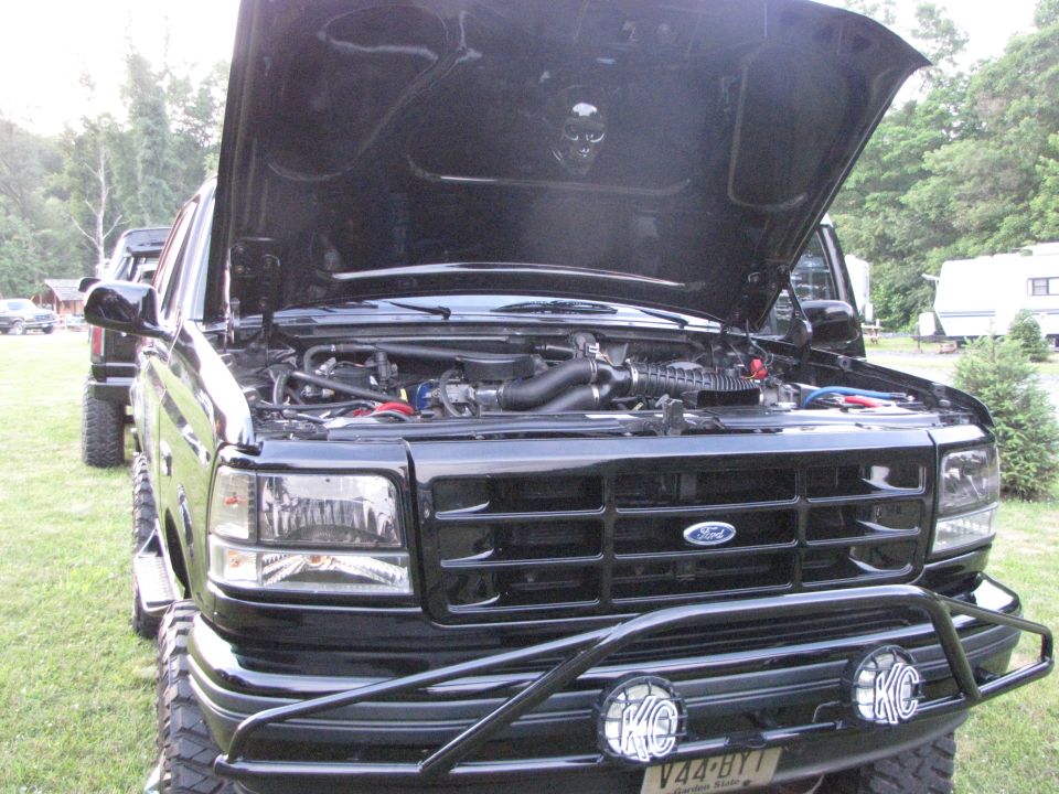Black Ford F-Series truck, hood open, showing engine. Grille indicates 1992-1997 model year