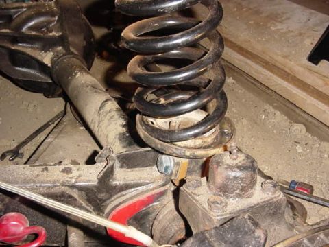 1992 Ford Bronco - This image shows a close-up view of a vehicle's rear axle, coil spring, and shock absorber, likely during maintenance or repair.