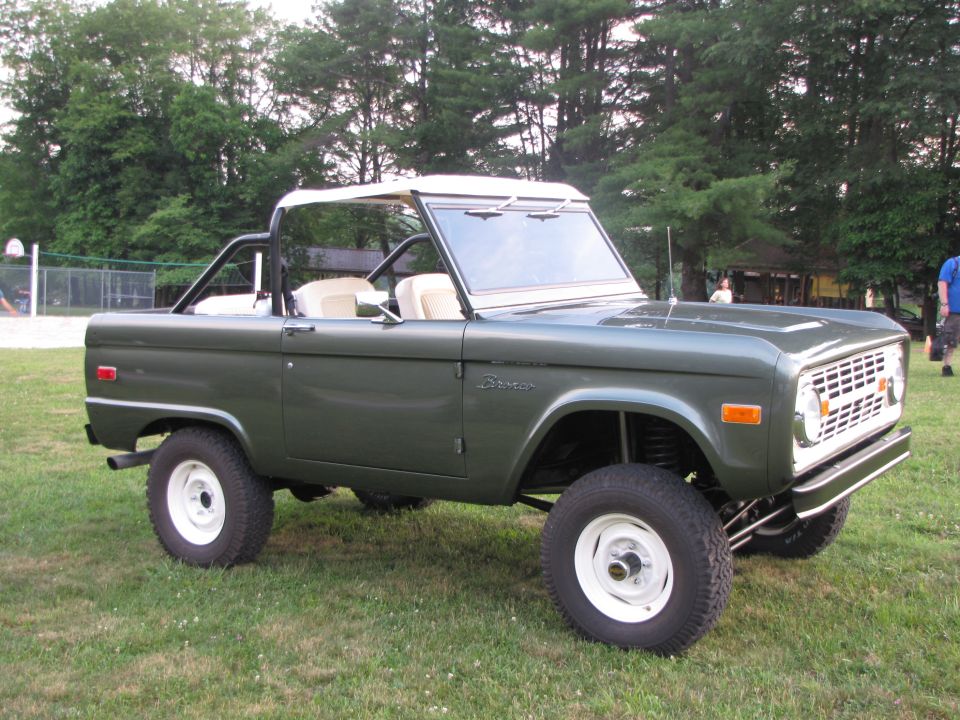 1979 Ford Bronco parked on grass with trees in background