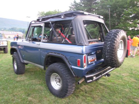 1979 Ford Bronco - A blue 1978 Ford Bronco is seen from the rear, equipped with a roof rack and spare tire.