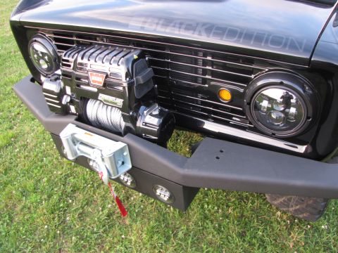 1979 Ford Bronco - This black Bronco features a winch, modern LED headlights, and "BLACK EDITION" text visible on the grille.