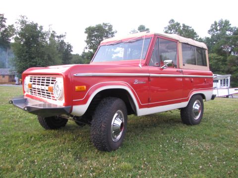 1979 Ford Bronco - This red and white Ford Bronco from 1979 features a tan soft top and a classic grille design.