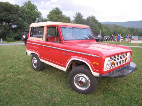1979 Ford Bronco - A red 1978 Ford Bronco is parked on a grassy field during an outdoor event.