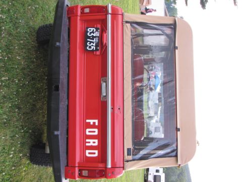 1979 Ford Bronco - Rear view of a red 1978 Ford Bronco, identifiable by its body style and taillights.