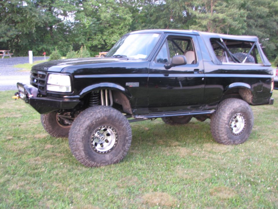 Black lifted SUV with off-road tires and roll cage