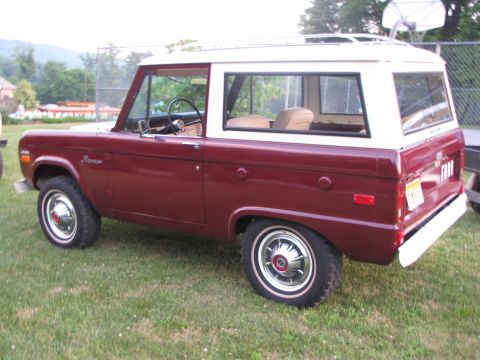 1979 Ford Bronco - Maroon and white Ford Bronco from the side, showing its classic body style.