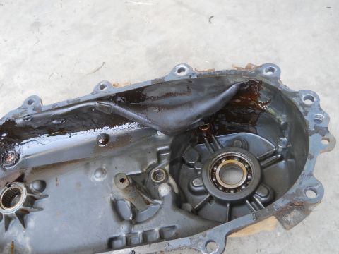 1992 Ford Bronco - Close-up view of a damaged transmission housing, revealing a bearing and oil accumulation.